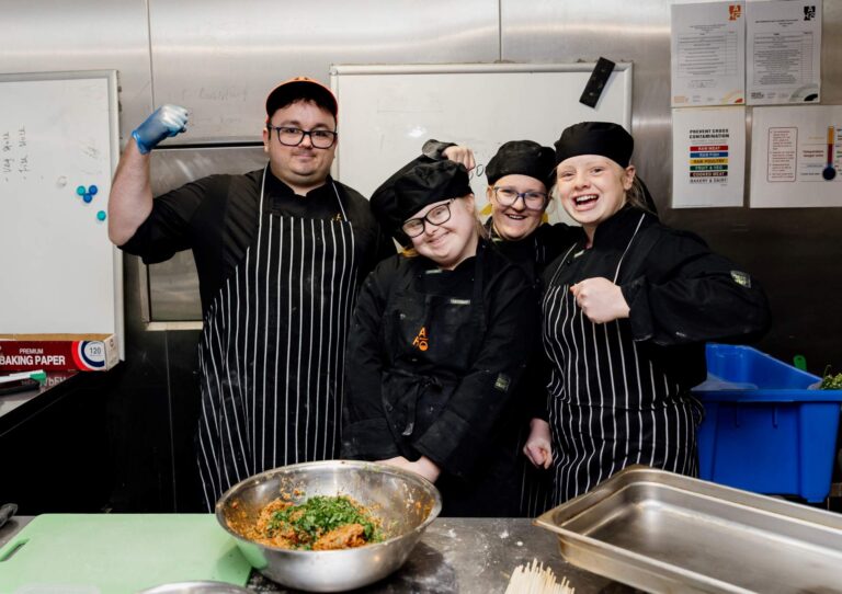 A group of students training in a commercial kitchen setting